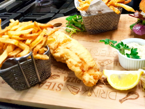 Poisson fris accompagné de frites maison Fish and chips sur planche en bois